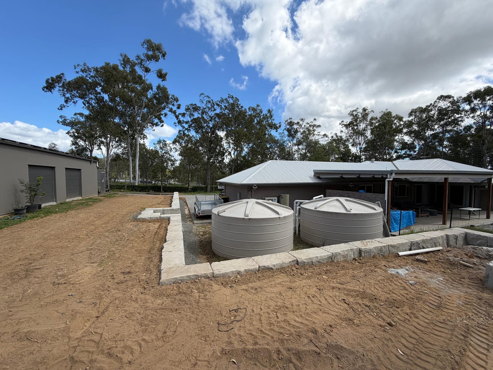 Water tank pad with retaining wall and site preparation