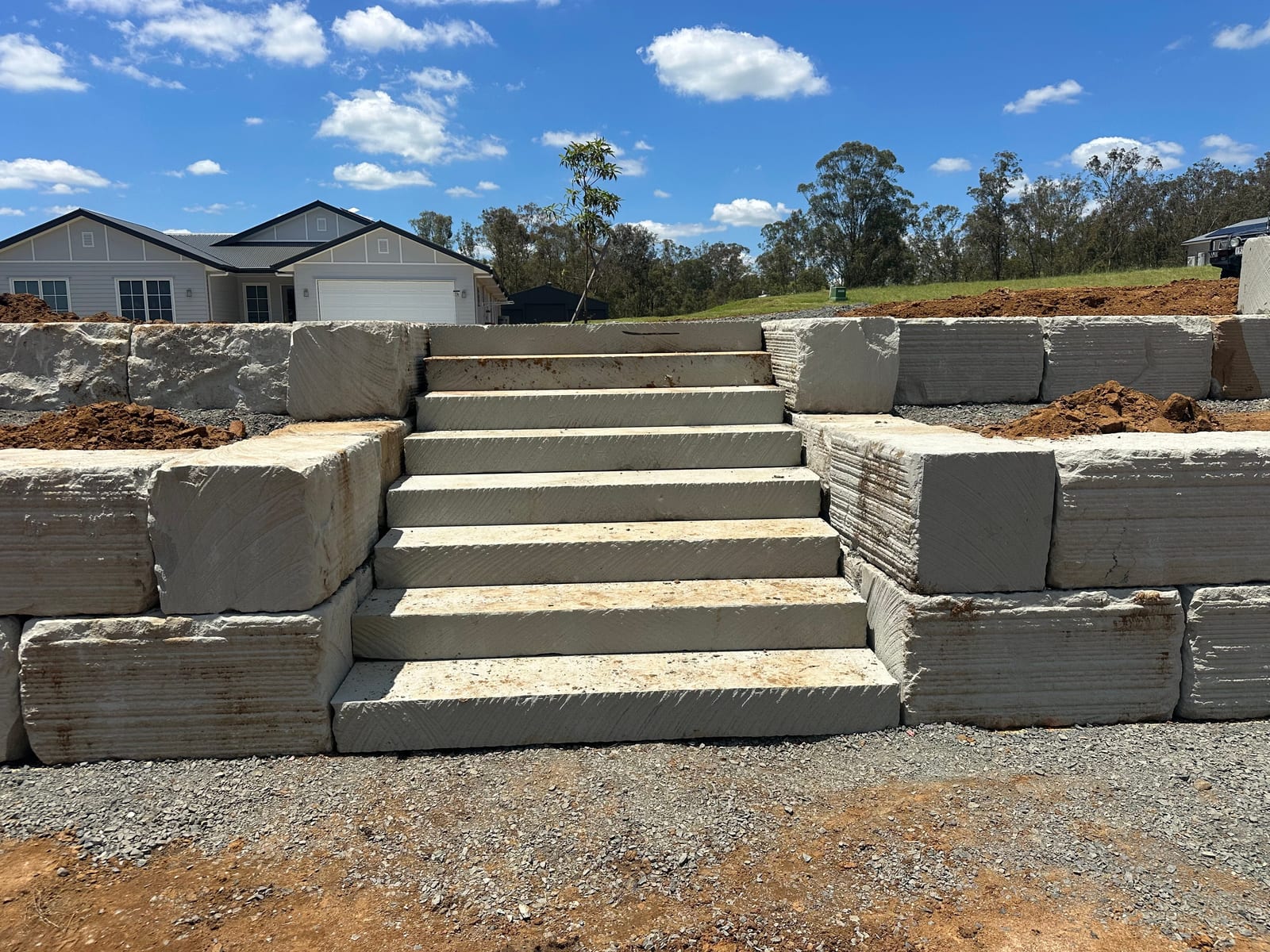 Concrete sleeper retaining wall with integrated steps on a residential property